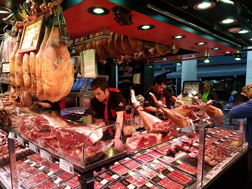 Personas de pie frente al mostrador de exhibición de alimentos