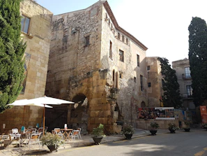 Historic stone walls of Mostar framing the welcoming entrance of Mostarika café.
