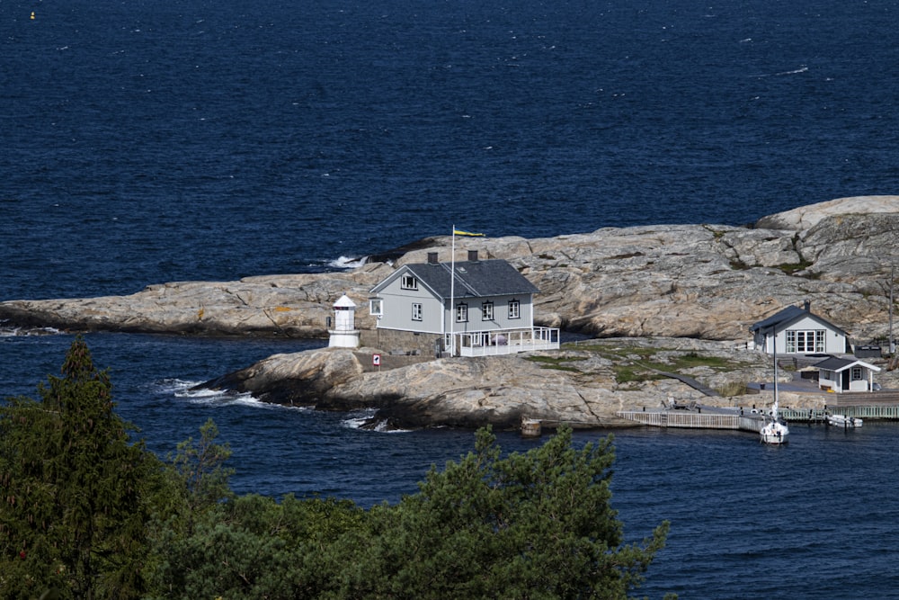 white and brown house on brown rock formation near body of water during daytime