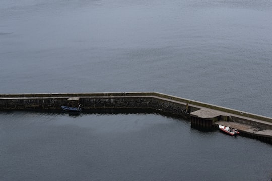 brown wooden dock on body of water during daytime in Inchkeith United Kingdom