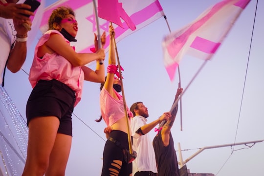 woman in pink tank top and black shorts holding flags in Jerusalem Israel