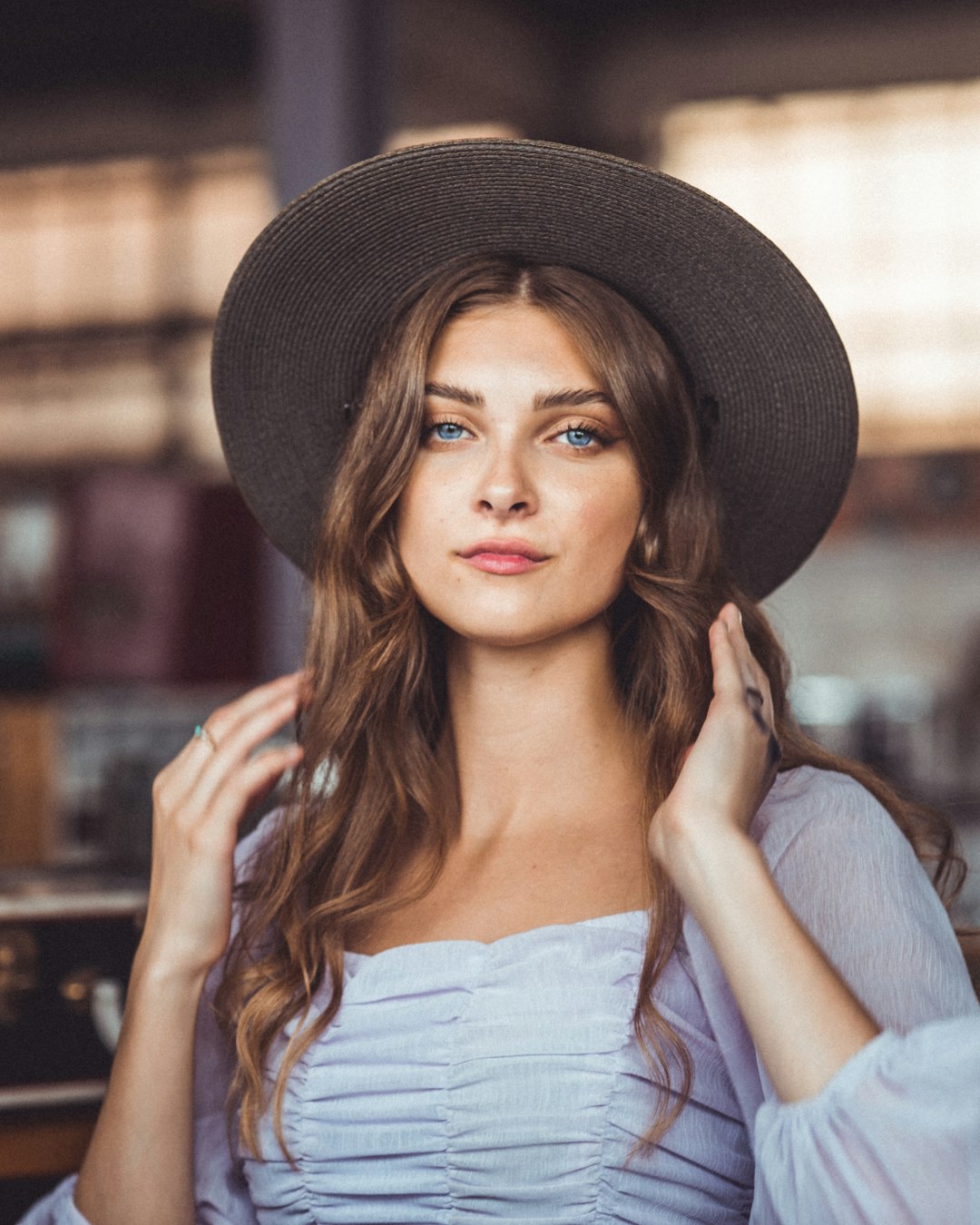 woman in white off shoulder top wearing black fedora hat