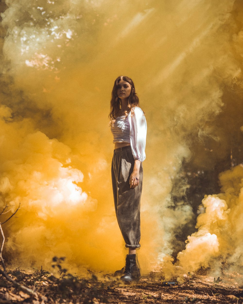 woman in white long sleeve shirt and black pants standing on brown grass field