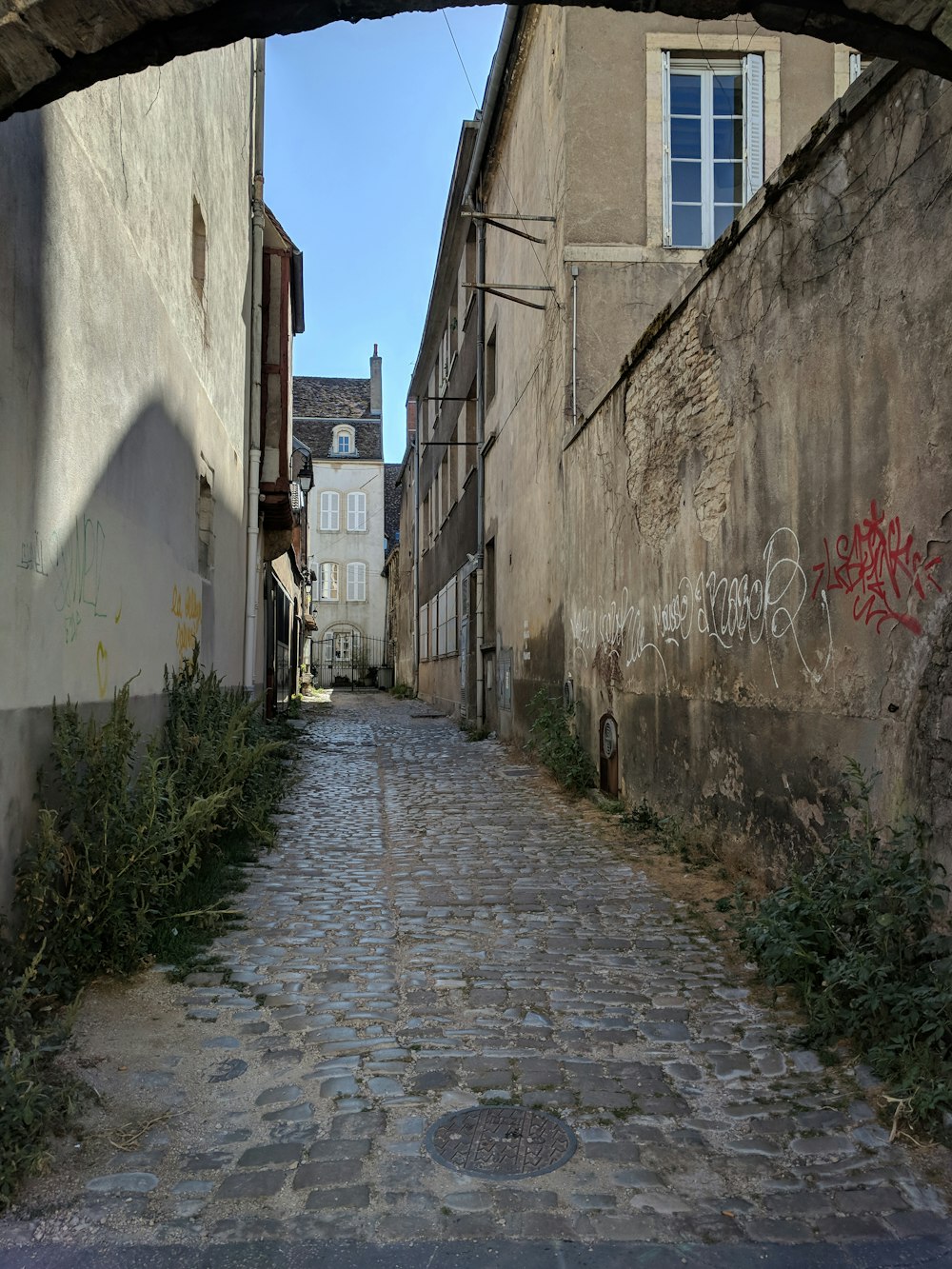 gray concrete pathway between concrete buildings during daytime