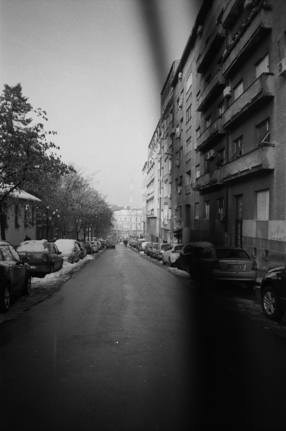 grayscale photo of cars parked on side of road