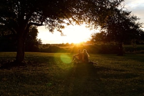 A happy couple enjoying a sunset picnic in a park.