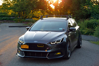 A friendly Keren Auto Sales agent handing car keys to a smiling new driver in New York.
