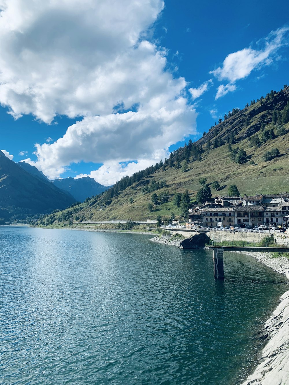 green mountain beside body of water under blue sky during daytime