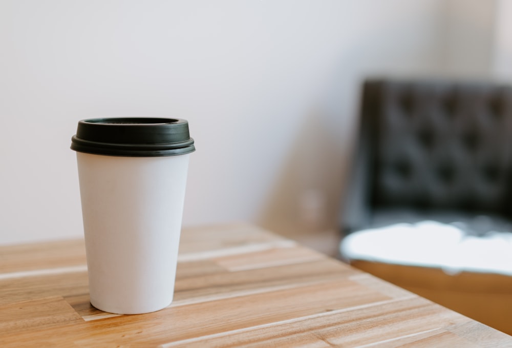 white disposable cup on brown wooden table