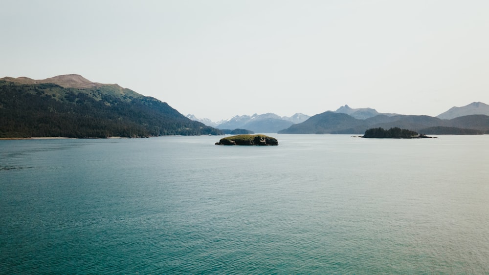 green and brown mountains beside body of water during daytime