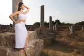 Lara Croft cosplay standing on ancient ruins at sunset, evoking a sense of adventure.