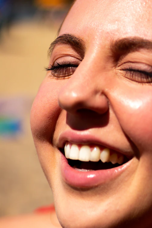 Smiling patient showing natural teeth after dentística treatment.