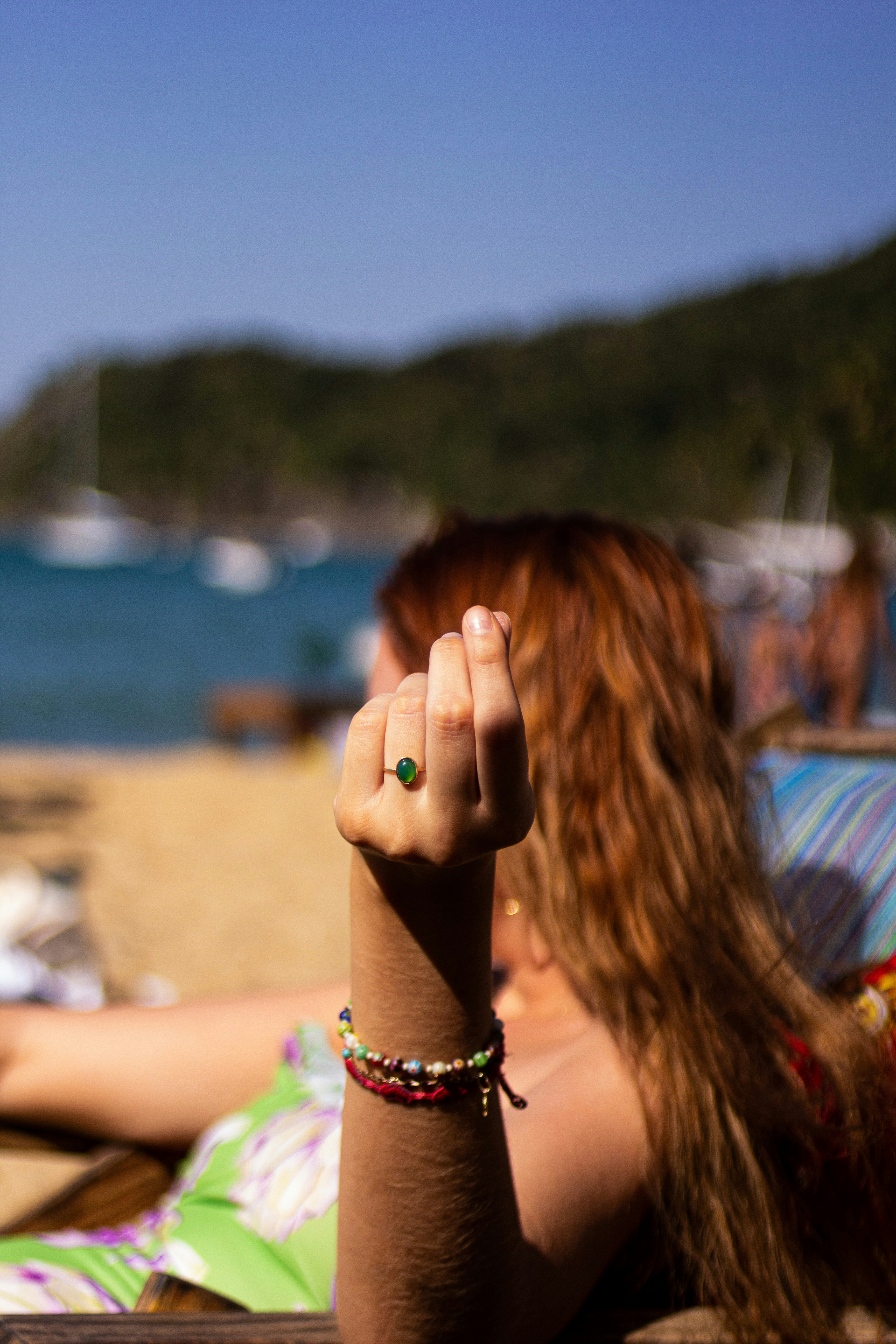 woman in black and white beaded bracelet covering her face with her hand