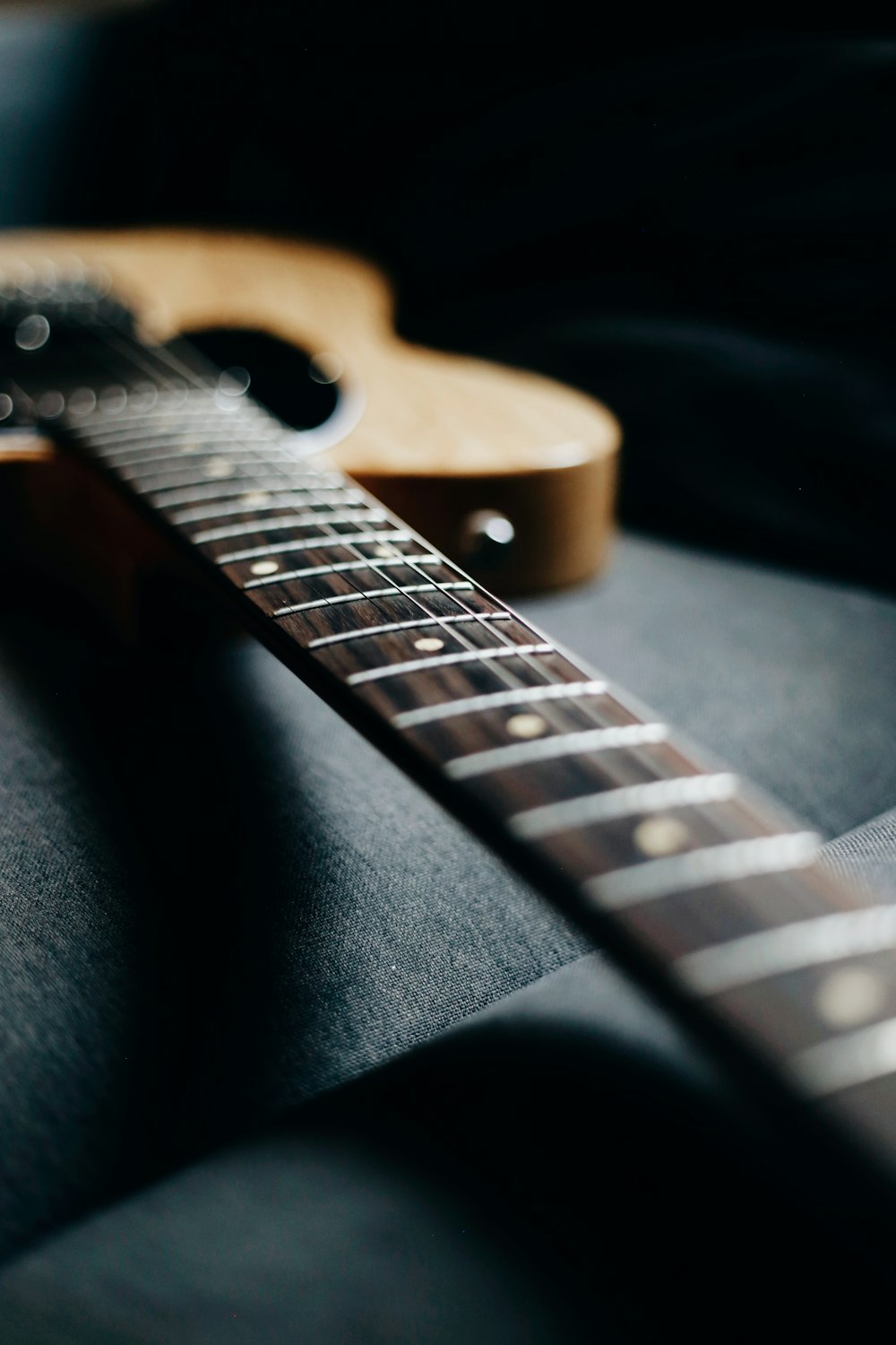 brown guitar pick on black textile