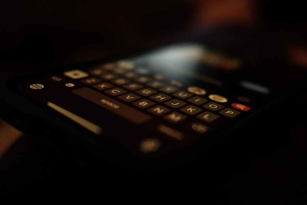 Téléphone QWERTY noir allumé dans une pièce sombre