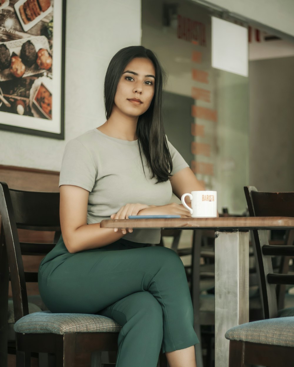 woman in white crew neck t-shirt and blue denim jeans sitting on chair