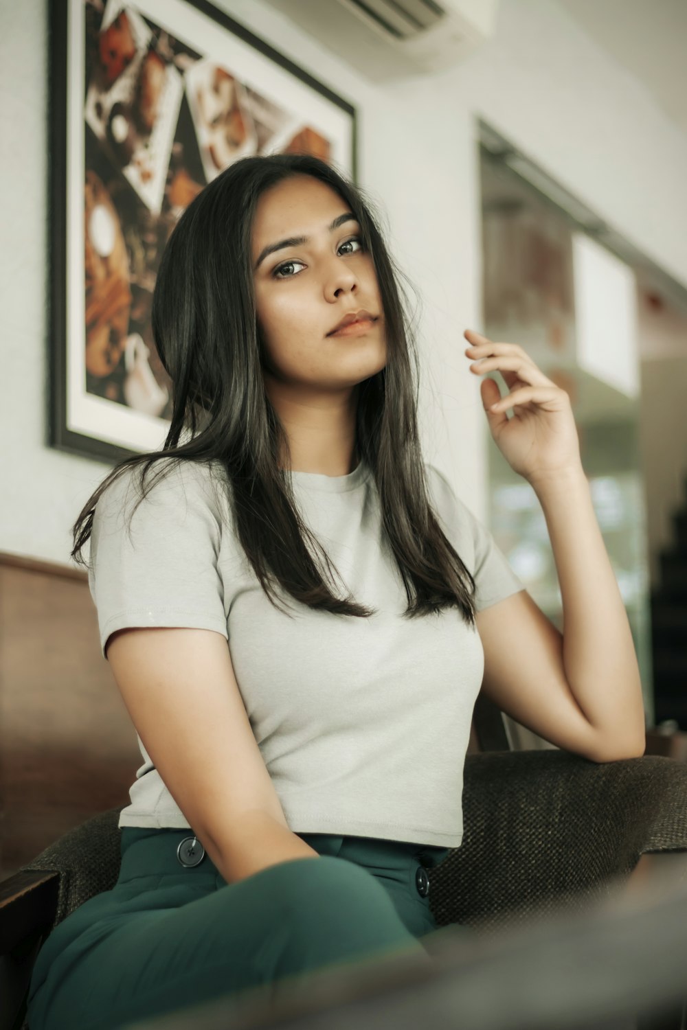 woman in white crew neck t-shirt sitting on black sofa