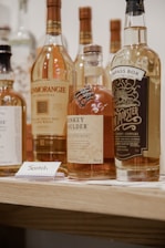 four bottles on brown wooden shelf