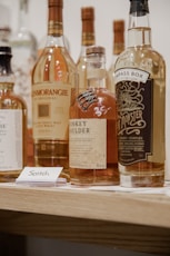 four bottles on brown wooden shelf