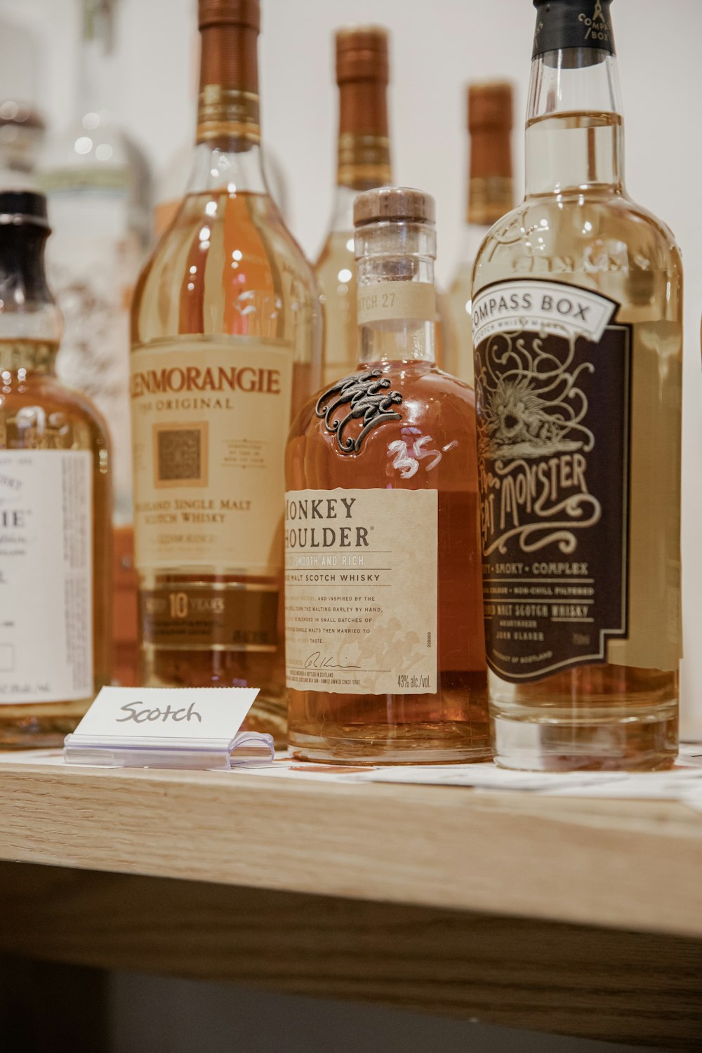 four bottles on brown wooden shelf