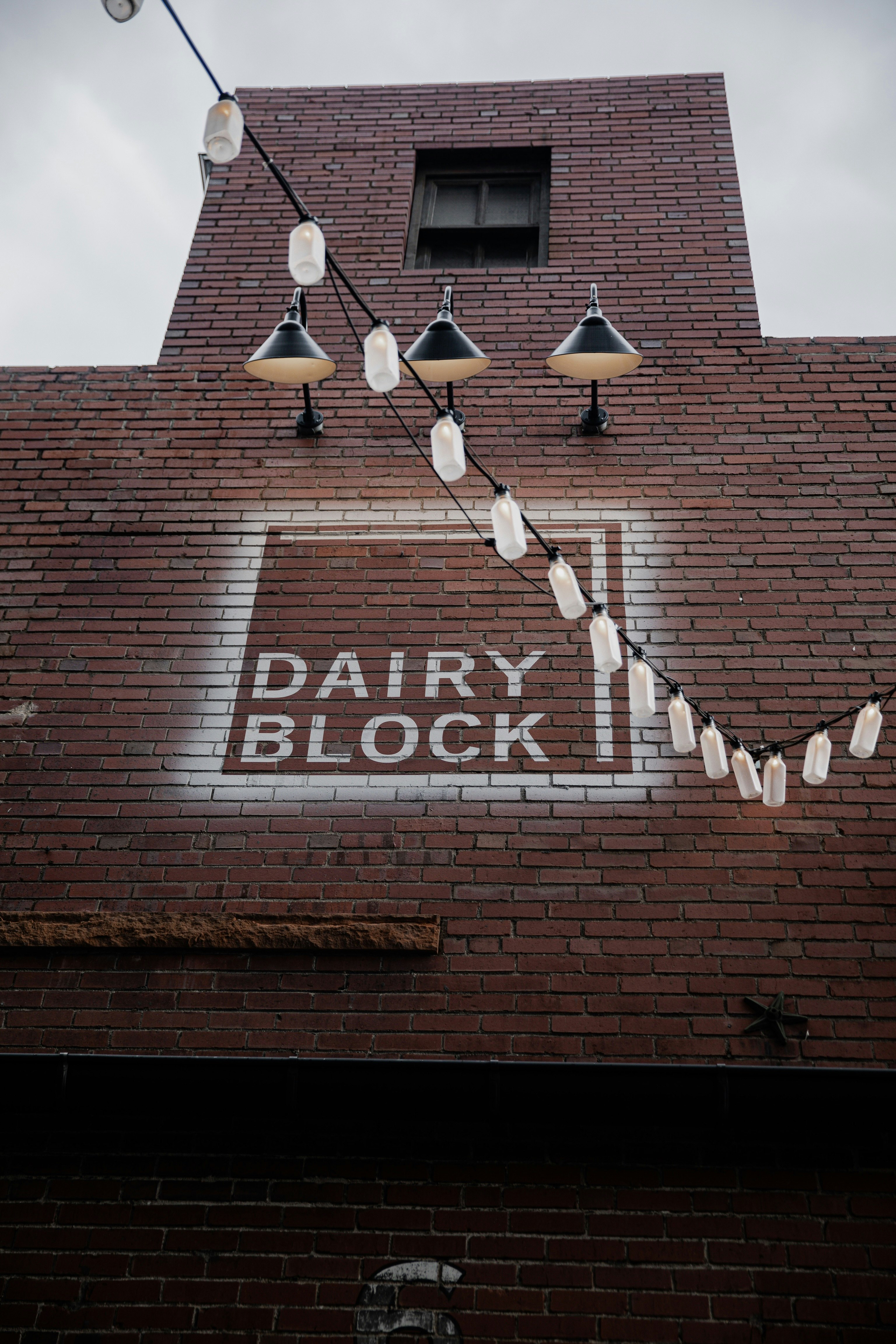 brown brick building with white and black pendant lamps