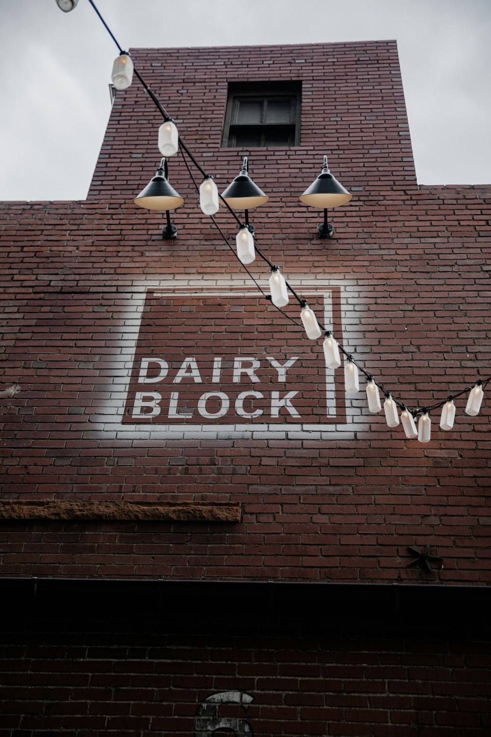 brown brick building with white and black pendant lamps