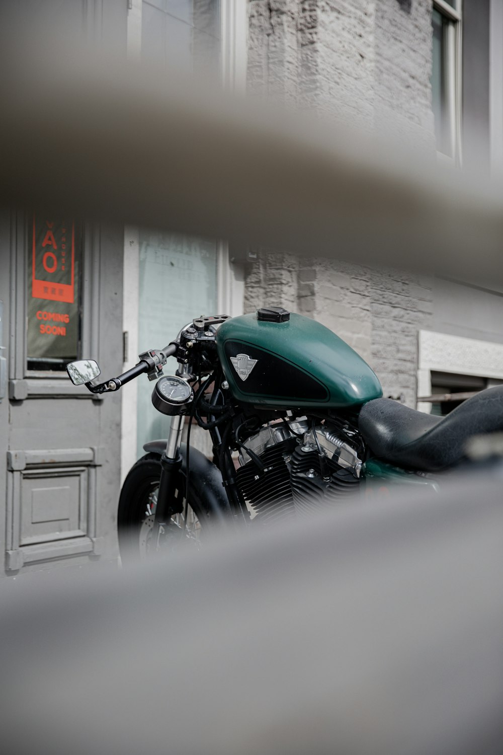 green and black motorcycle parked beside white wall
