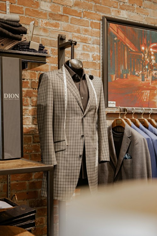 Black suit jacket on a mannequin against an exposed brick wall