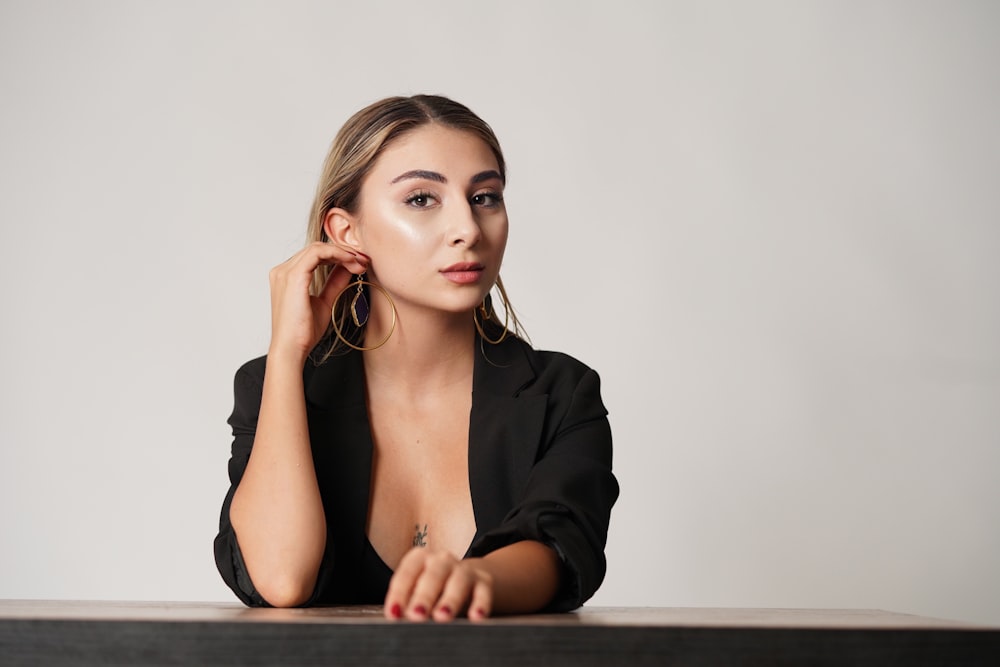 woman in black blazer sitting by the table