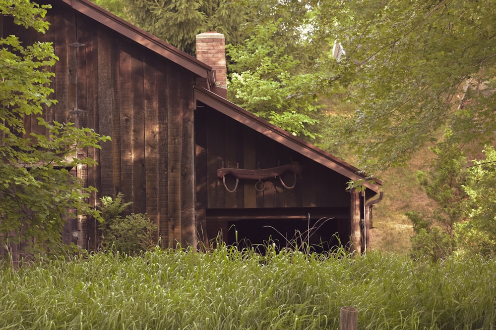 brown wooden house surrounded by green grass and trees during daytime