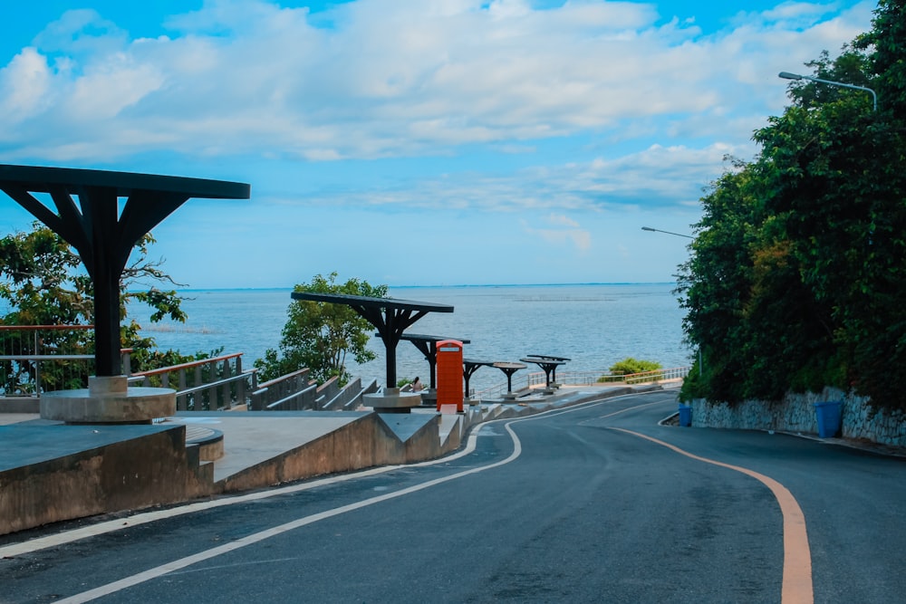 red and black road sign near body of water during daytime