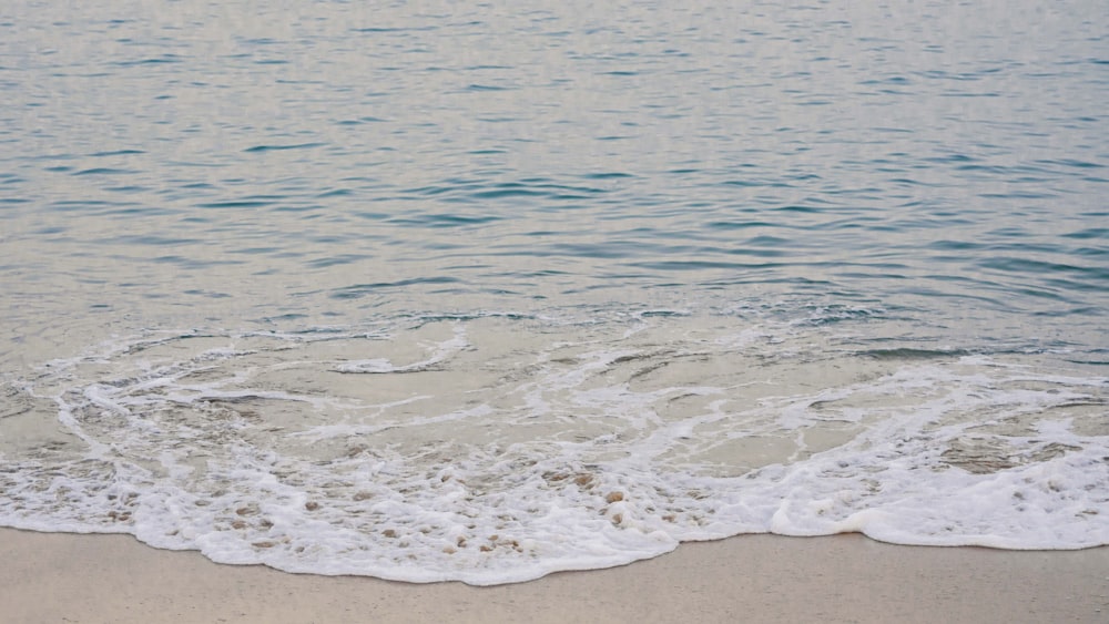 sea waves crashing on shore during daytime