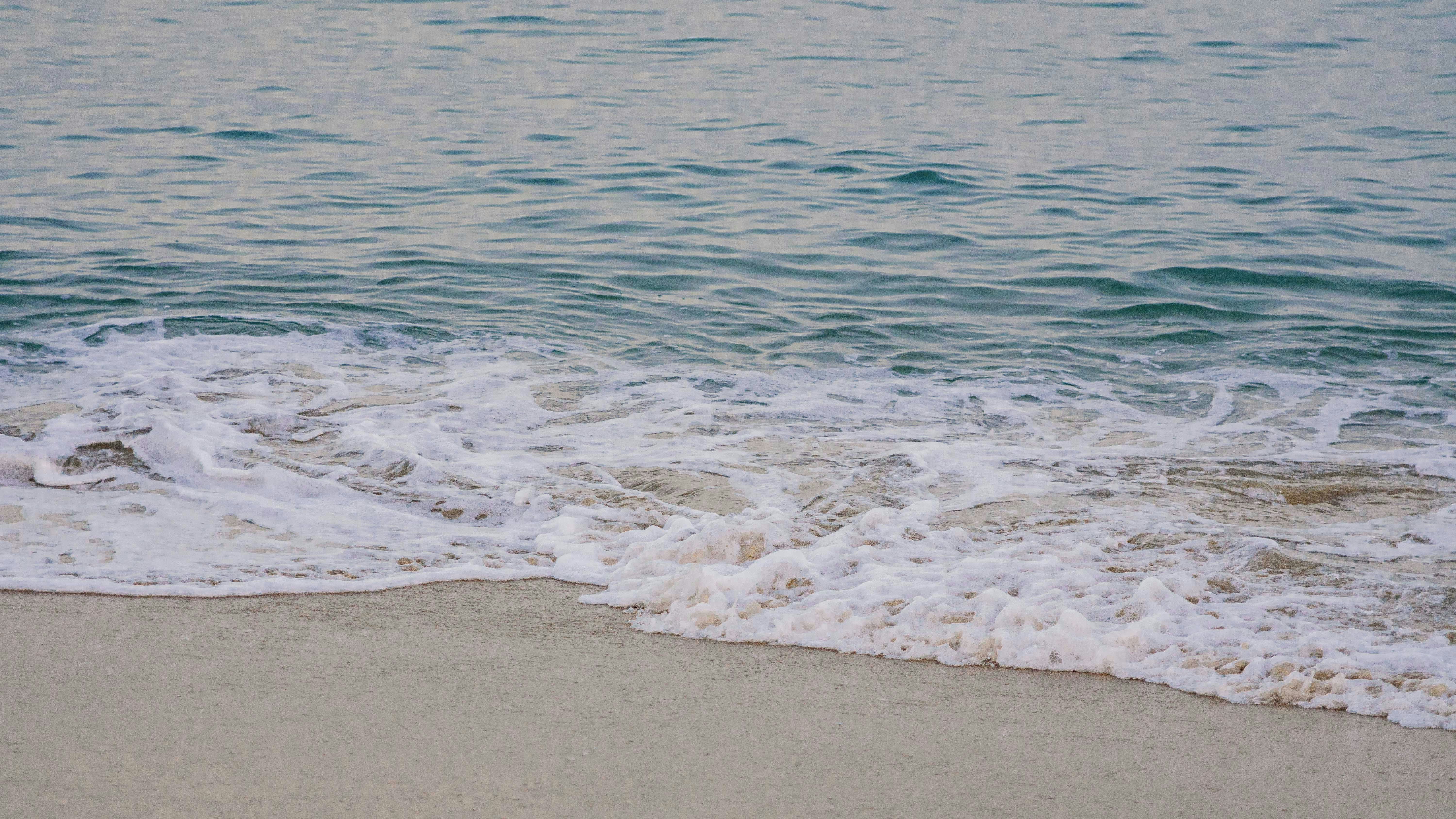 sea waves crashing on shore during daytime