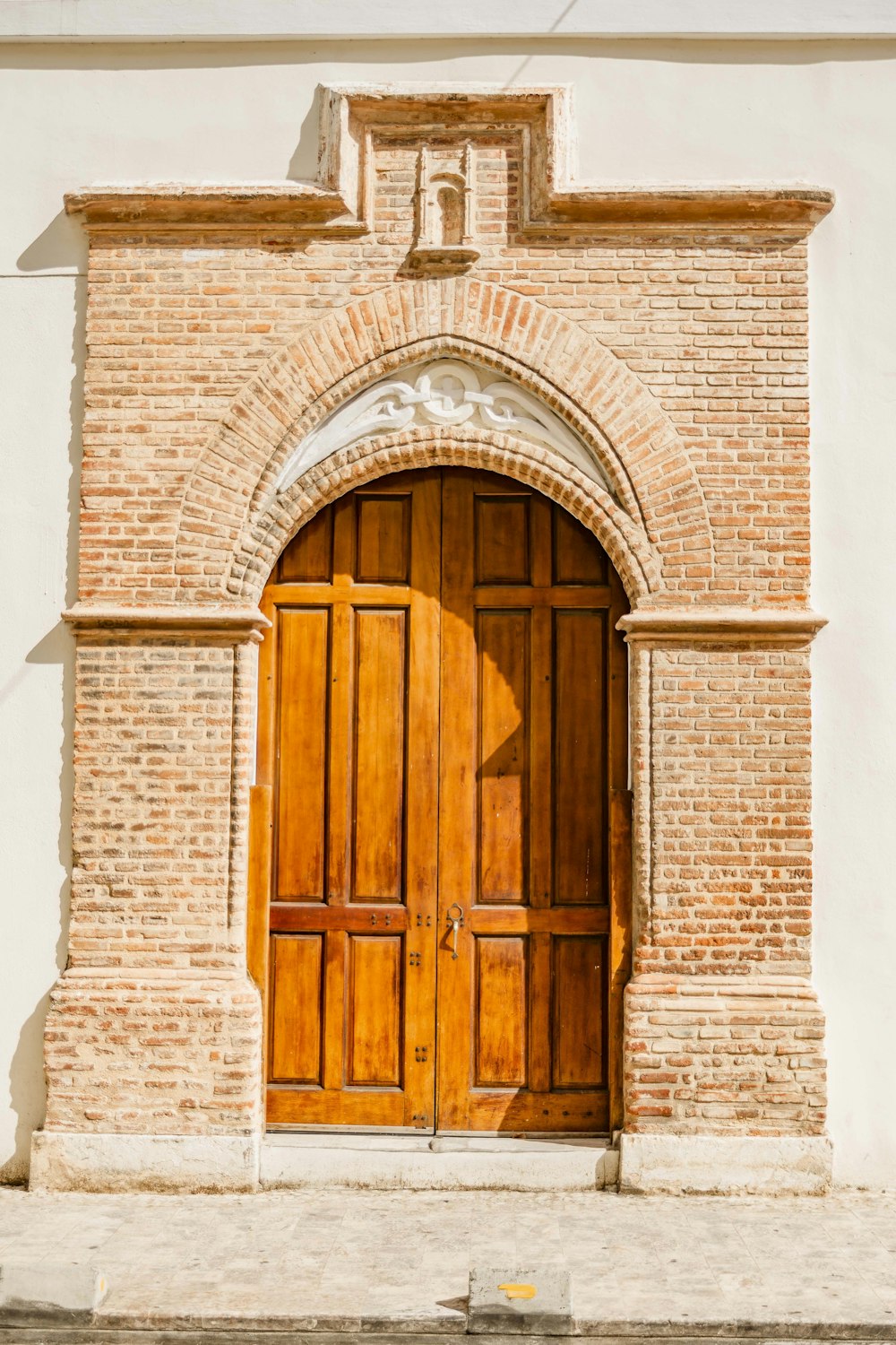 brown wooden door on white concrete wall