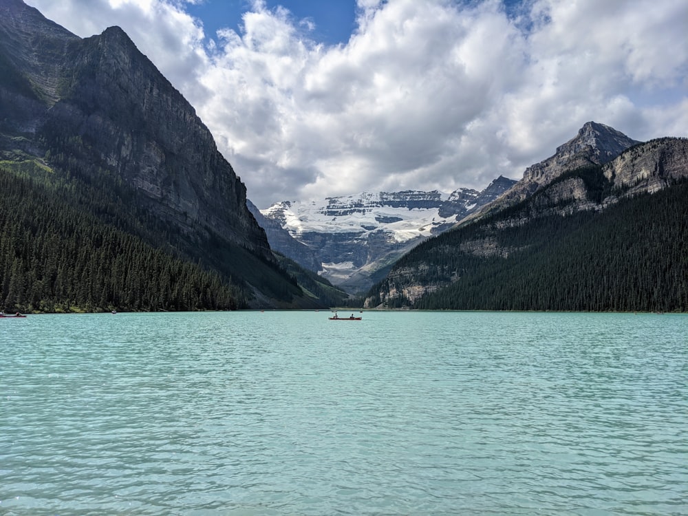 green and brown mountains beside body of water under blue sky during daytime