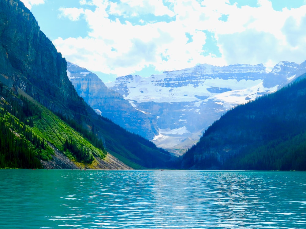 green and black mountains beside body of water under blue sky during daytime