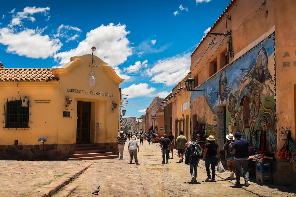 personas que caminan por la calle cerca de los edificios durante el día