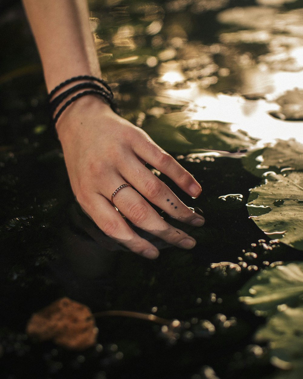 Persona que lleva reloj de pulsera de eslabones de plata que sostiene piedra negra