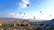hot air balloons flying over the mountains during daytime