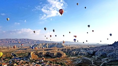 hot air balloons flying over the mountains during daytime