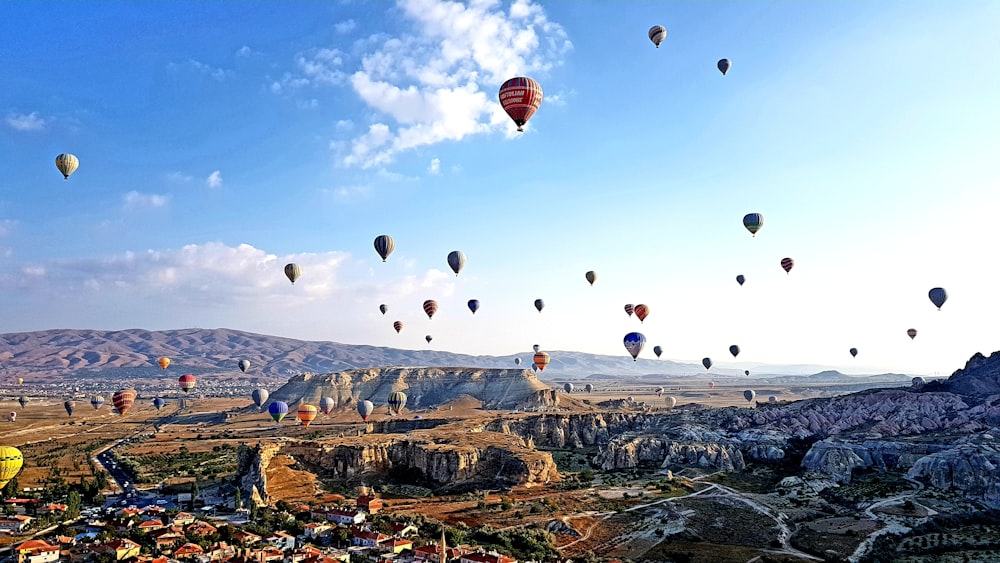 hot air balloons flying over the mountains during daytime