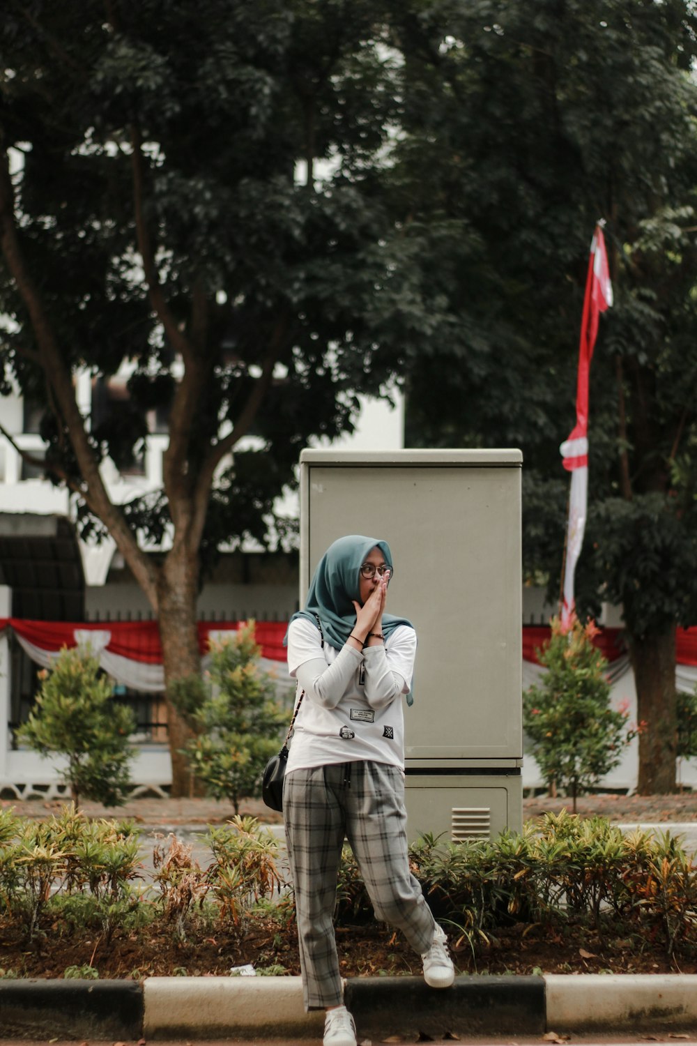 man in white polo shirt standing near red and white flag during daytime