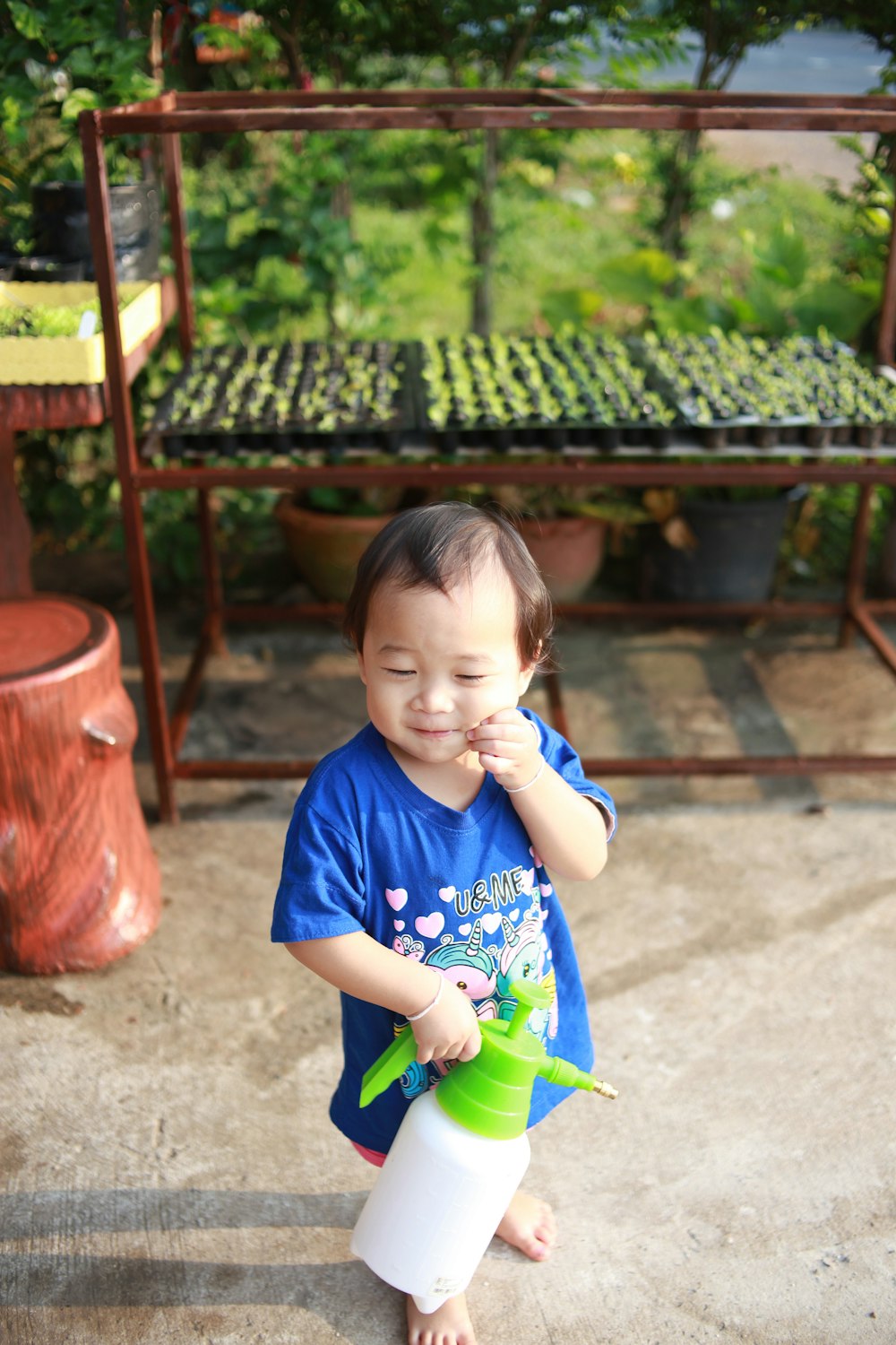 girl in blue crew neck t-shirt holding green plastic toy