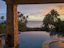 A serene view of the villa's infinity pool overlooking the ocean at sunset.