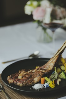 A sizzling tomahawk steak grilled to perfection with elegant plating in a luxurious garden setting.