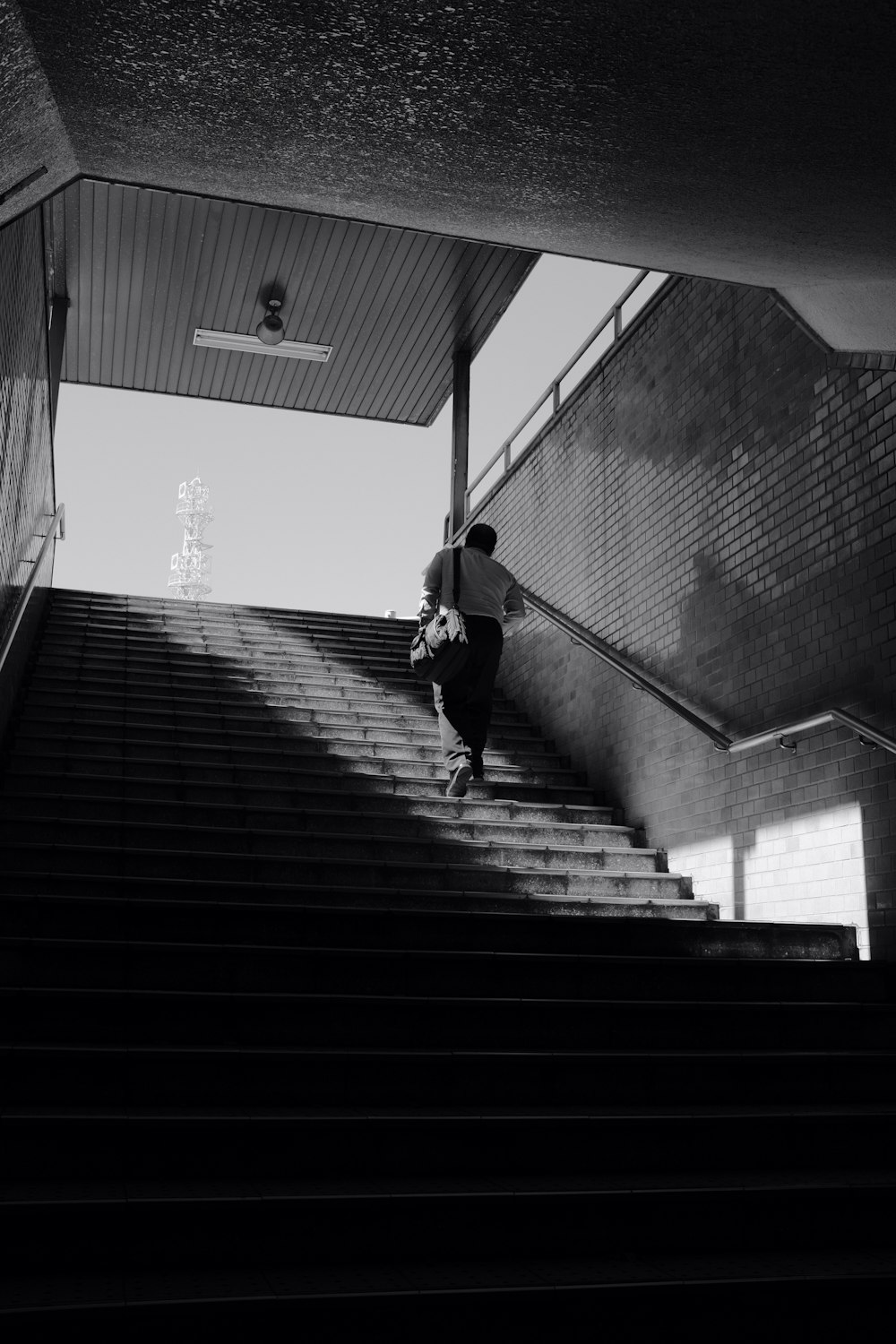 man in black jacket and pants walking on stairs