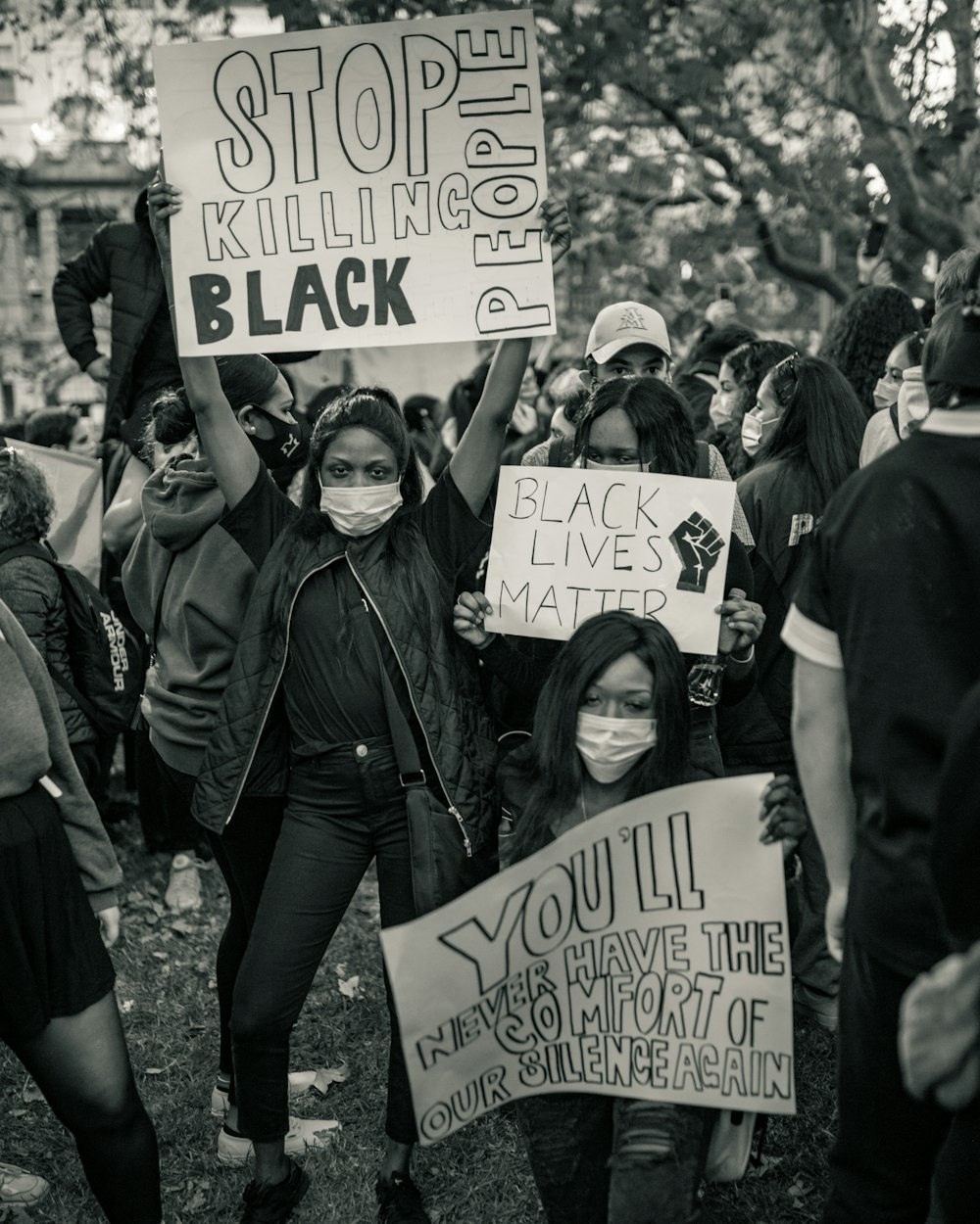 group of people holding white and black banner