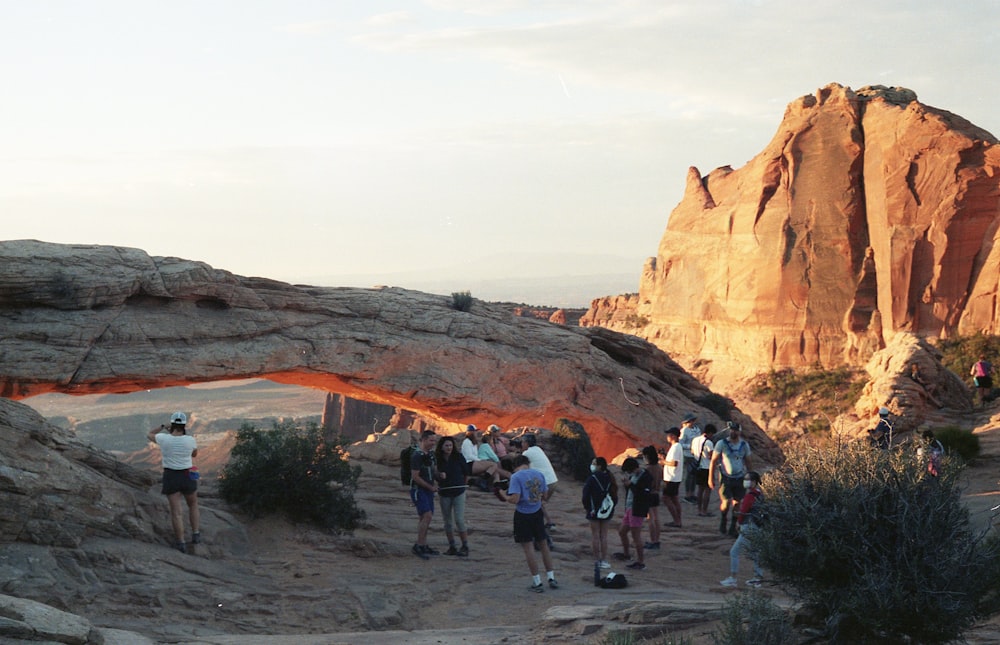 people walking on pathway between brown rock formation during daytime