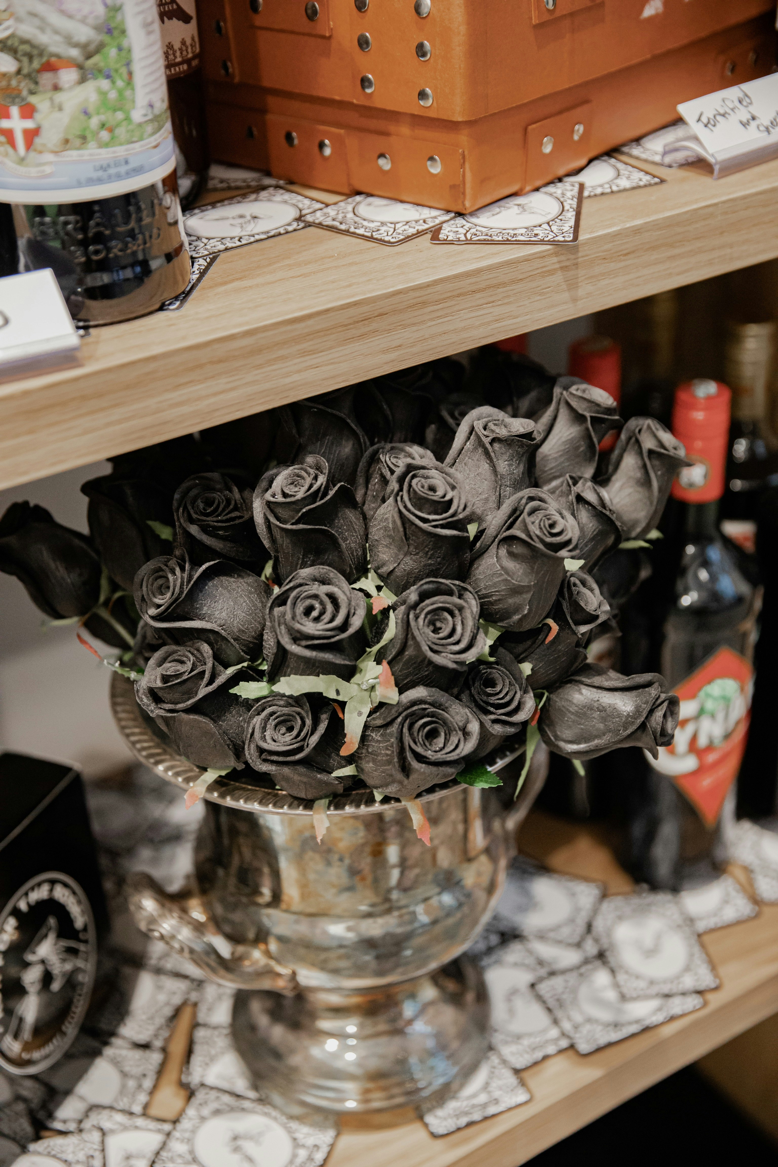 red and black bouquet on brown wooden shelf