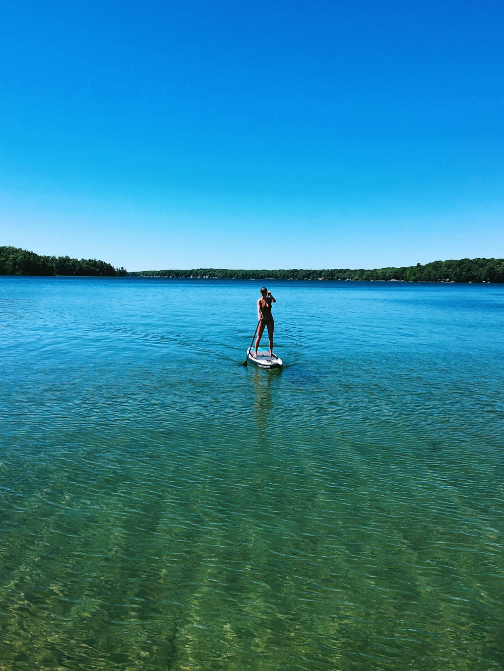 woman in white dress standing on body of water during daytime